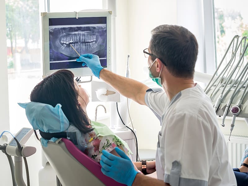 Doctor dentist showing patient's teeth on X-ray