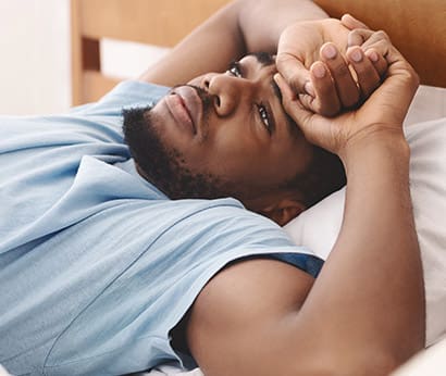 Black man in bed suffering from insomnia and sleep disorder